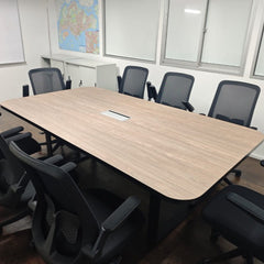 Conference room with a large wooden table and black chairs, featuring a map on the wall.