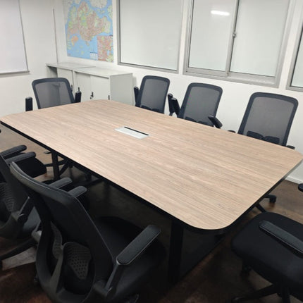 Conference room with a large wooden table and black chairs, featuring a map on the wall.