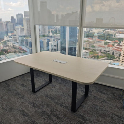Beige conference table in an office with a cityscape view through large windows.
